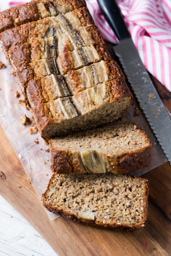 vertical image of sliced banana bread on cutting board