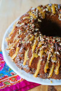 apple pumpkin bundt cake topped with caramel and nuts