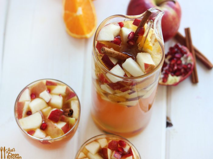 apple cider sangria by lexi's clean kitchen in a pitcher and two glasses.