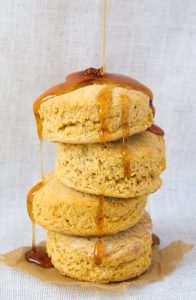 a stack of vegan sweet potato biscuits drizzled in bee-free honey