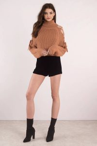 You need the Lara Lace Up Turtleneck Sweater. Featuring lace up shoulder detail, long sleeves, and turtleneck. Pair with your favorite leggings for a cozy look.