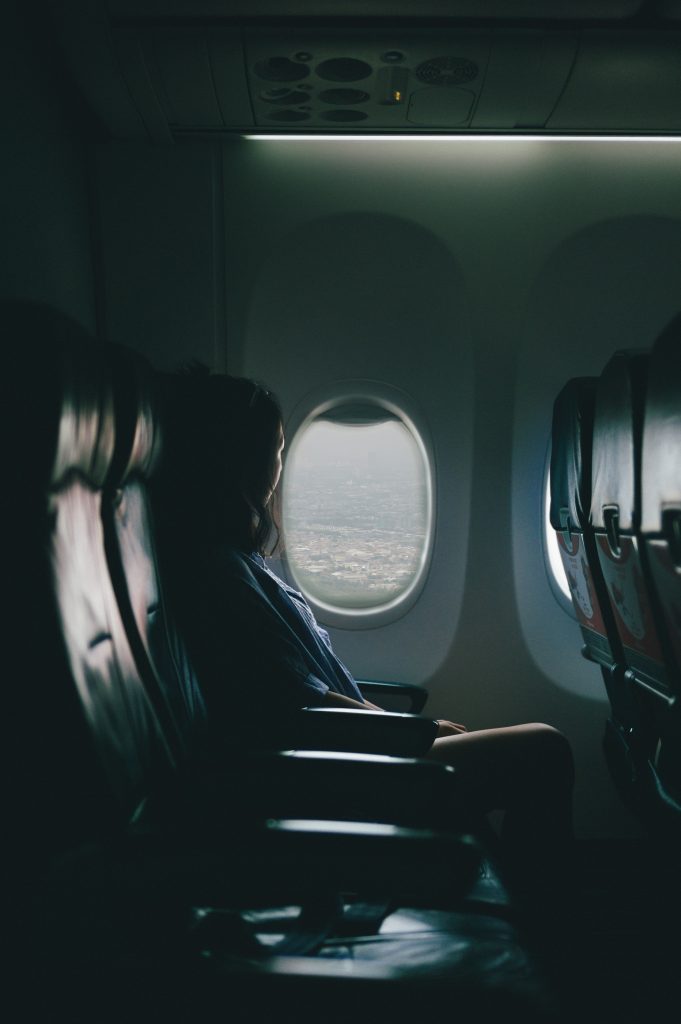 budget travel destinations: woman in a plane