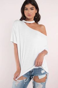 Feelin' it in the White Tia Off Shoulder Tee. A basic tee reinvented with its choker neckline and asymmetric shoulder detail. This tunic is a little oversized which gives it that comfy tee feel and works great for tucking in. Pull off looking chill and casual with this off shoulder tee with ripped denim and heels or lace up ankle boots.