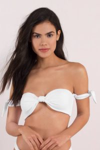Our Pretty Thoughts Off Shoulder Bikini Top features a bandeau style and knotted detail. Pair with Our Pretty Thoughts High Waisted Ribbed Bikini Bottom.