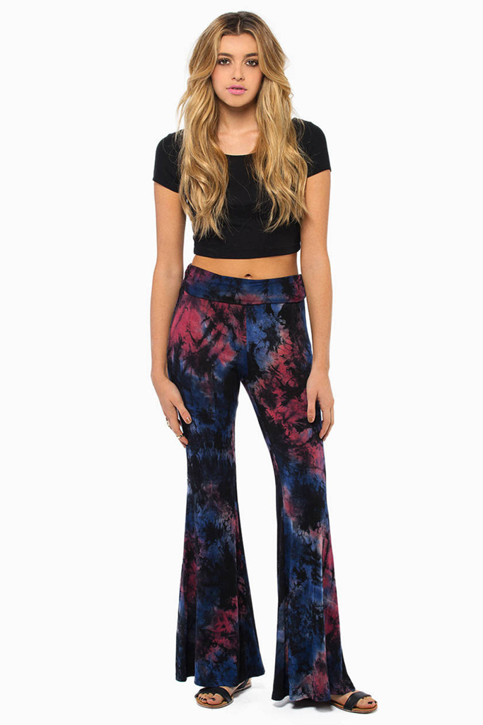 A girl in tie dyed pants and a black crop top