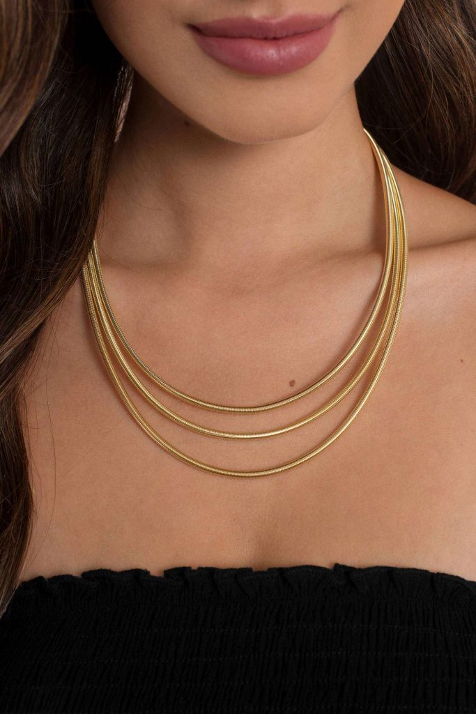 A girl wearing a gold layered necklace